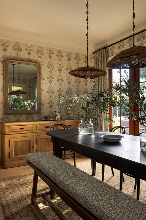 Sala de jantar com papel de parede, madeira e luminárias em fibras naturais