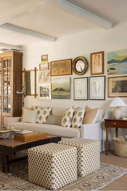 Composição de sala com obras de arte, tecidos estampados e peças de madeira